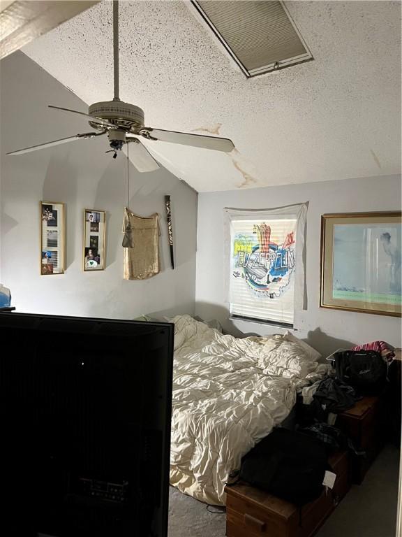 bedroom with a textured ceiling and ceiling fan