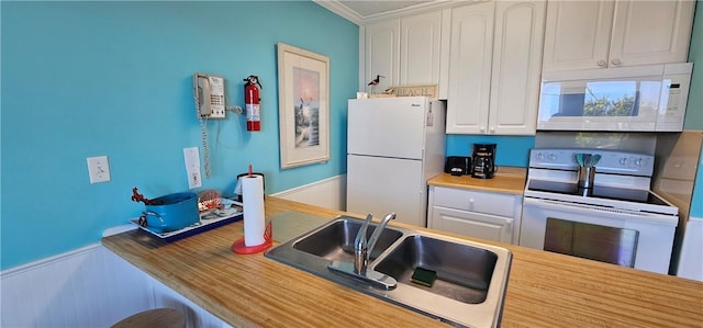 1175 N Beachview Dr Unit 311, Jekyll Island, GA 31527 - kitchen with white appliances, a sink, white cabinetry, wainscoting, and light countertops