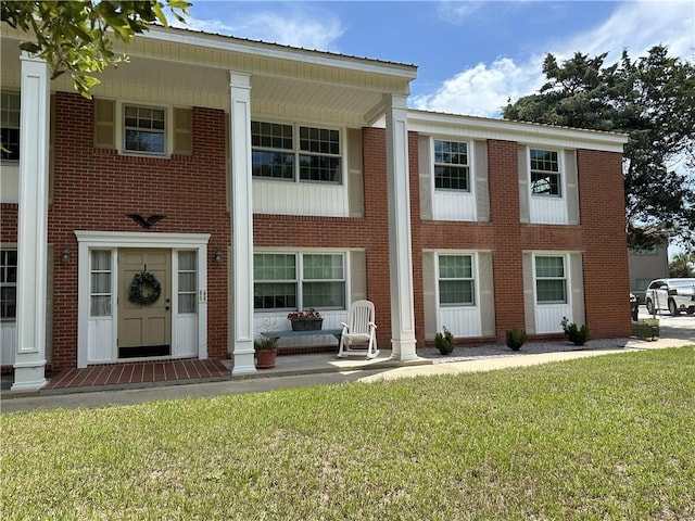 view of front of house featuring covered porch and a front yard