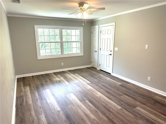 empty room with ceiling fan, dark wood-type flooring, and ornamental molding