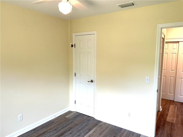 unfurnished bedroom with ceiling fan and dark hardwood / wood-style flooring