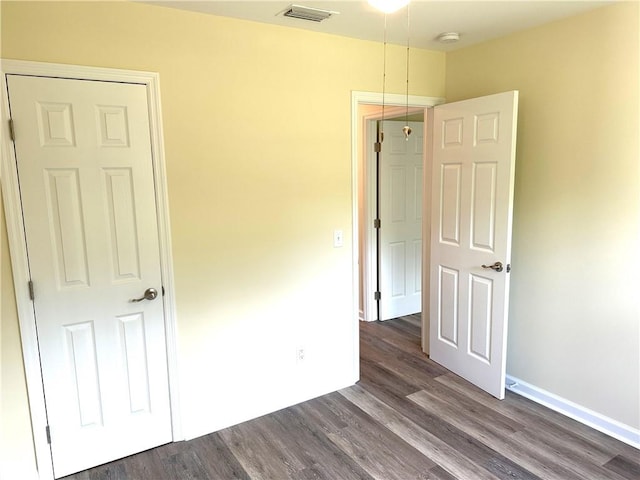 unfurnished bedroom with dark hardwood / wood-style flooring