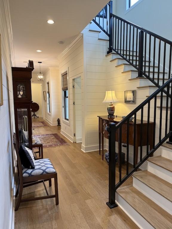 stairs featuring baseboards, ornamental molding, recessed lighting, and wood finished floors