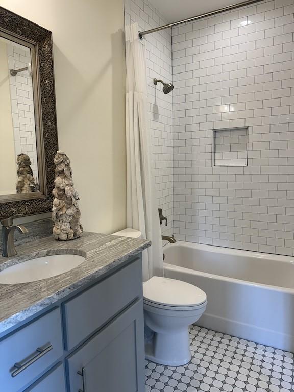 full bathroom with vanity, tile patterned flooring, shower / tub combo, and toilet