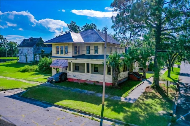 back of property with a balcony and a yard