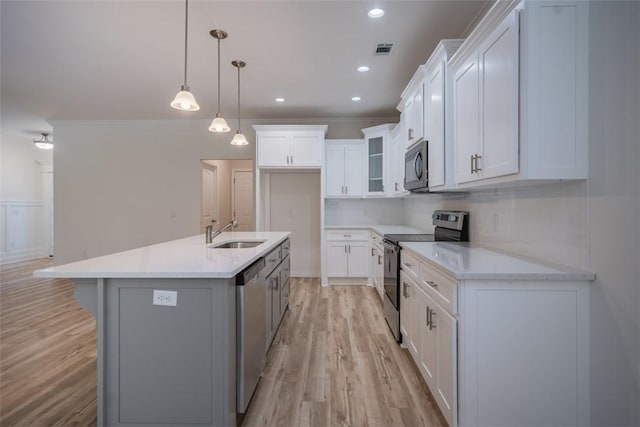 860 Kaitlyn Ave, Odum, GA 31555 - kitchen with a kitchen island with sink, white cabinets, stainless steel appliances, and light wood-type flooring