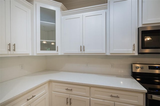 860 Kaitlyn Ave, Odum, GA 31555 - kitchen featuring light stone countertops, stainless steel appliances, backsplash, crown molding, and white cabinets