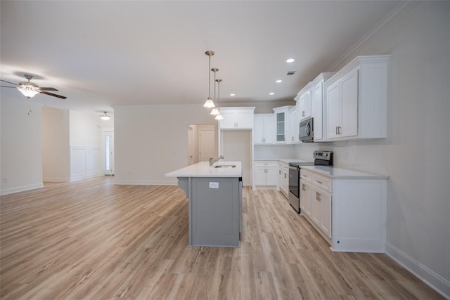 860 Kaitlyn Ave, Odum, GA 31555 - kitchen with a kitchen island with sink, white cabinets, decorative light fixtures, and appliances with stainless steel finishes