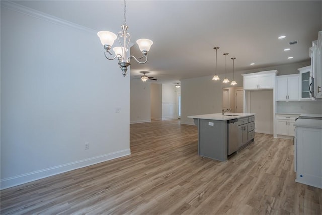 860 Kaitlyn Ave, Odum, GA 31555 - kitchen featuring white cabinetry, stainless steel dishwasher, light hardwood / wood-style floors, a center island with sink, and ceiling fan with notable chandelier