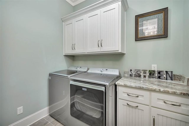 laundry room featuring cabinet space, washer and clothes dryer, and baseboards