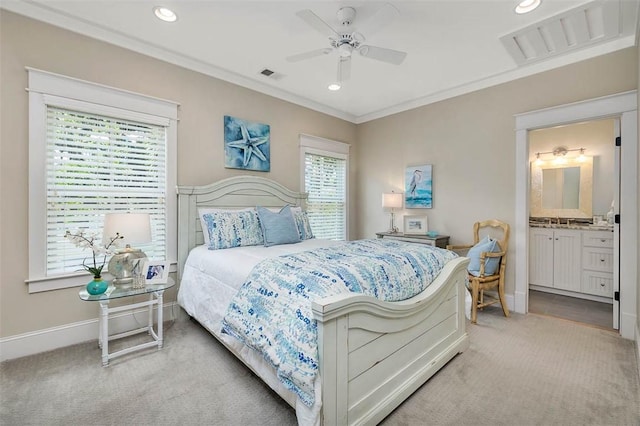 bedroom featuring light colored carpet, crown molding, baseboards, recessed lighting, and connected bathroom