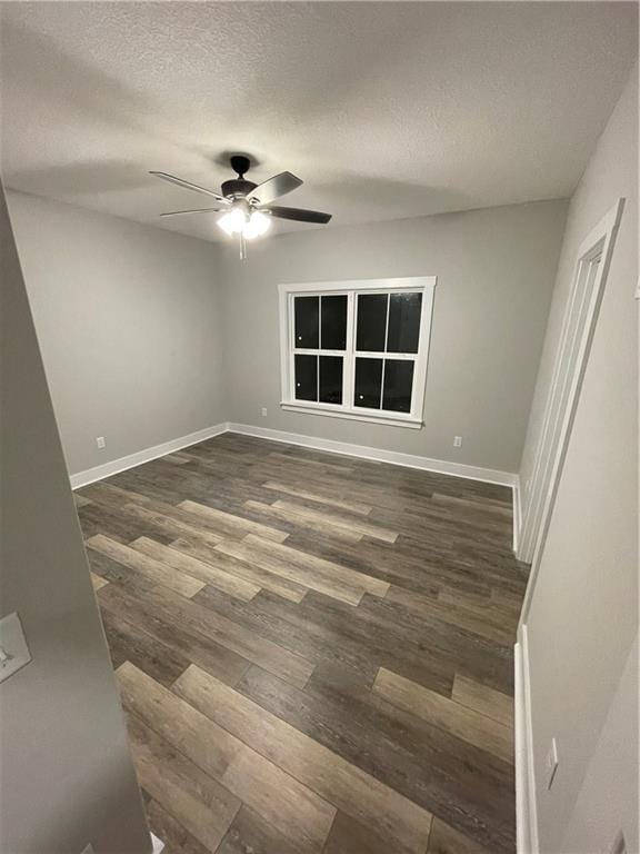 spare room featuring ceiling fan, dark hardwood / wood-style flooring, and a textured ceiling