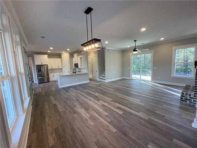 unfurnished living room with dark hardwood / wood-style floors, ceiling fan, crown molding, and sink