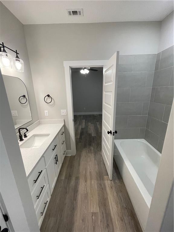 bathroom with ceiling fan, hardwood / wood-style floors, and vanity