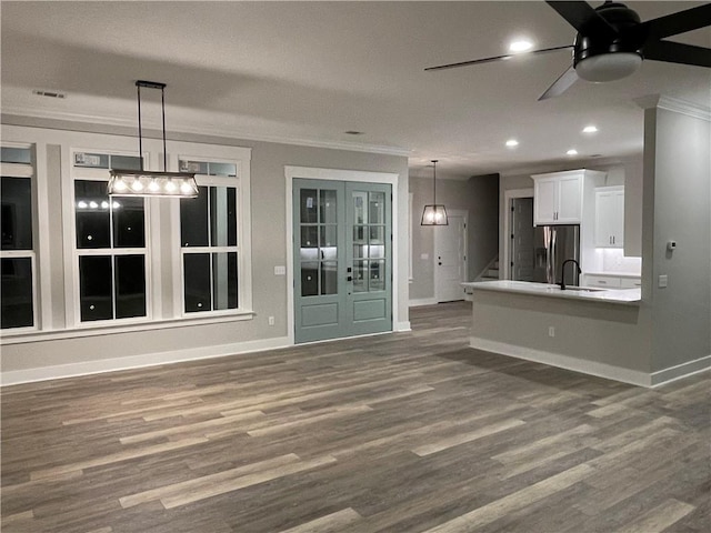 unfurnished living room with ceiling fan, dark hardwood / wood-style flooring, ornamental molding, and sink