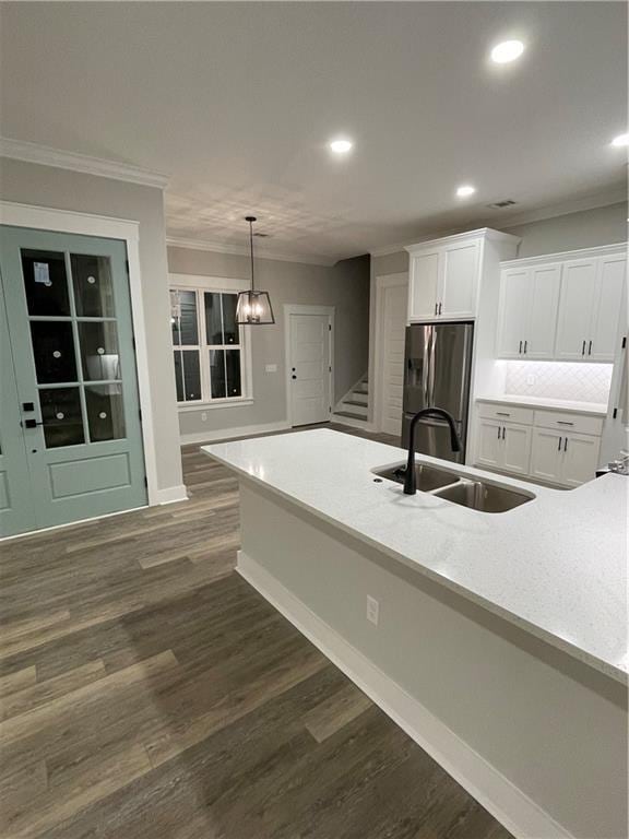 kitchen with white cabinetry, sink, dark hardwood / wood-style flooring, stainless steel refrigerator with ice dispenser, and decorative light fixtures