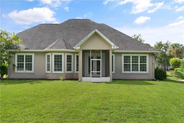 rear view of house with a sunroom and a yard