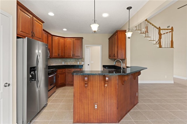 kitchen with pendant lighting, decorative backsplash, light tile patterned floors, kitchen peninsula, and stainless steel appliances