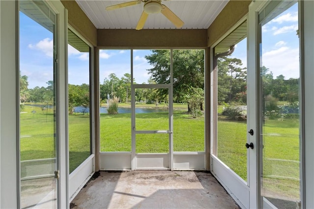 unfurnished sunroom featuring a wealth of natural light, a water view, and ceiling fan