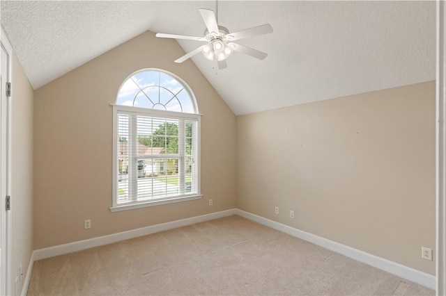 carpeted empty room featuring vaulted ceiling, ceiling fan, and a textured ceiling