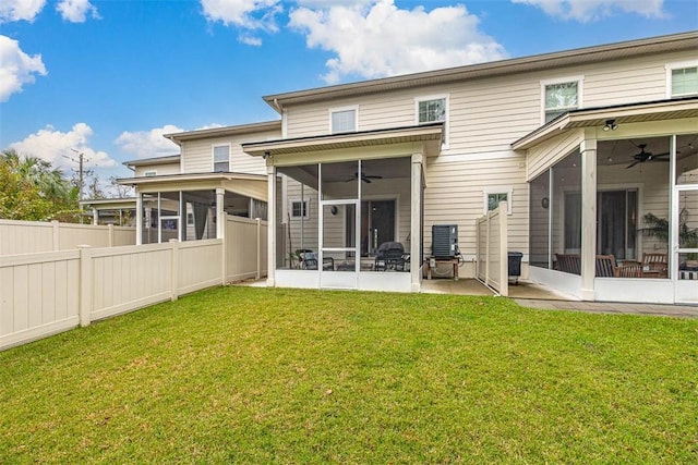 rear view of property featuring a patio, a sunroom, and a lawn