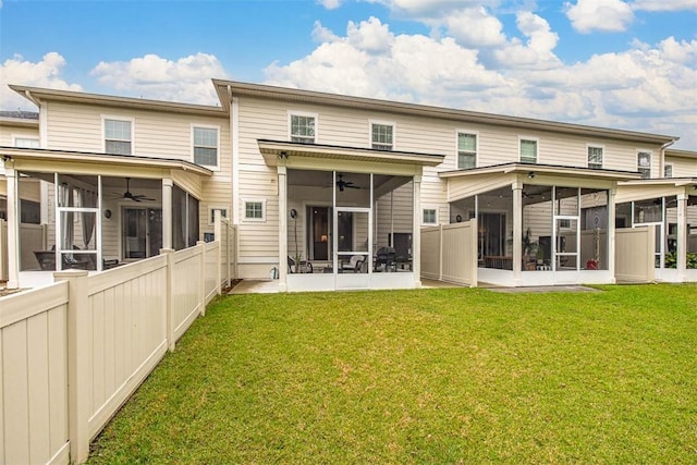 rear view of house featuring a yard, a sunroom, and ceiling fan