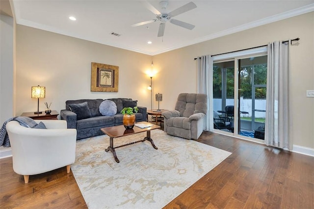 living room with dark hardwood / wood-style flooring, ornamental molding, and ceiling fan