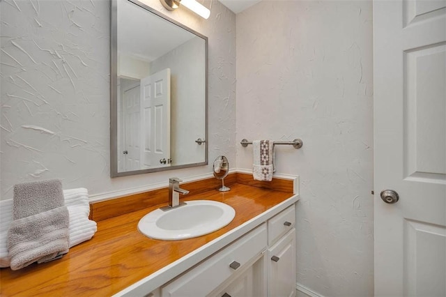 bathroom featuring vanity and a textured wall