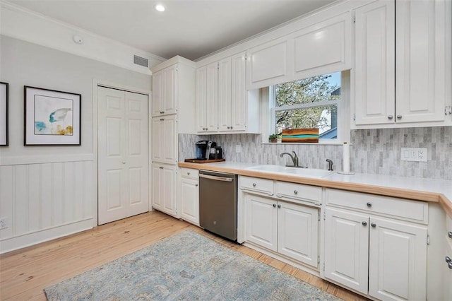 kitchen with visible vents, a sink, light countertops, white cabinets, and dishwasher