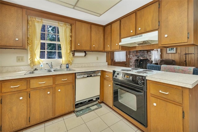 kitchen featuring white dishwasher, sink, light tile patterned floors, a fireplace, and black / electric stove