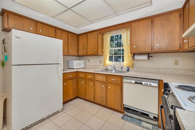 kitchen with sink, light tile patterned floors, and white appliances