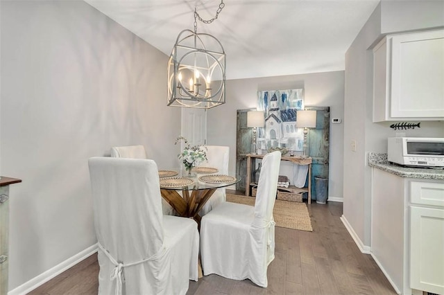 dining room with dark hardwood / wood-style floors and a notable chandelier