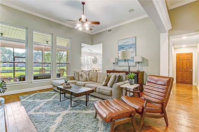 living room with light wood-style flooring, baseboards, and crown molding