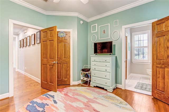 bedroom with baseboards, wood finished floors, and crown molding