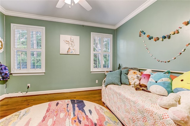 bedroom with baseboards, multiple windows, wood finished floors, and crown molding