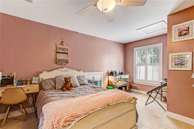 bedroom with attic access, light carpet, ceiling fan, a textured ceiling, and baseboards