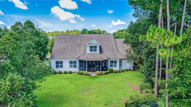 new england style home featuring a front yard and a sunroom