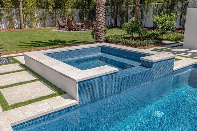 view of swimming pool featuring an in ground hot tub, a patio area, and a lawn