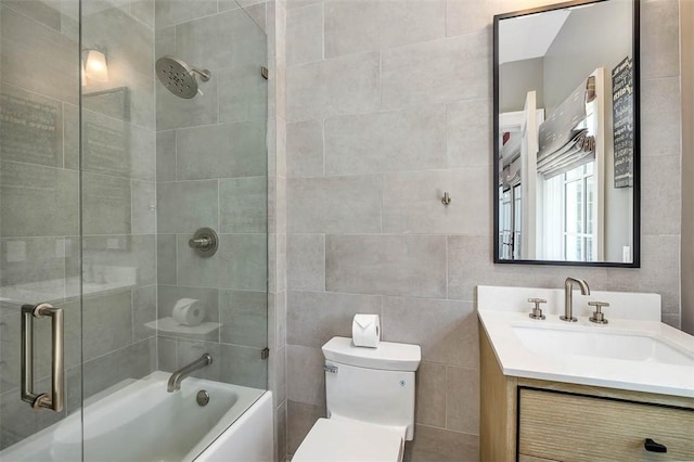 bathroom featuring vanity, toilet, and tile walls