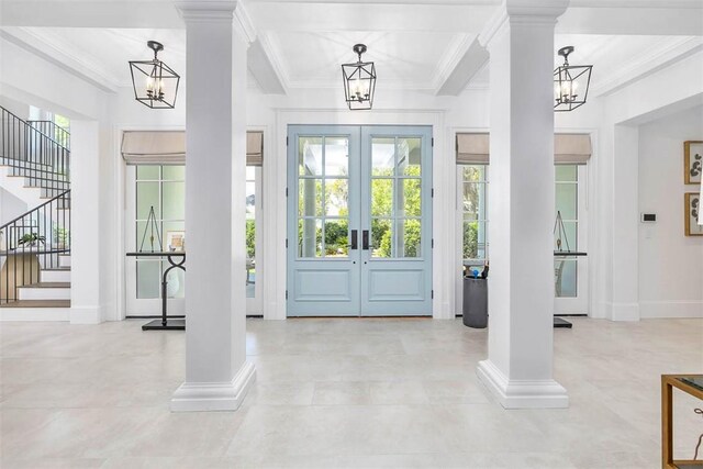 foyer featuring a chandelier, french doors, and decorative columns