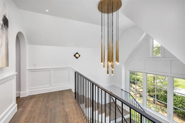 corridor with vaulted ceiling and hardwood / wood-style flooring