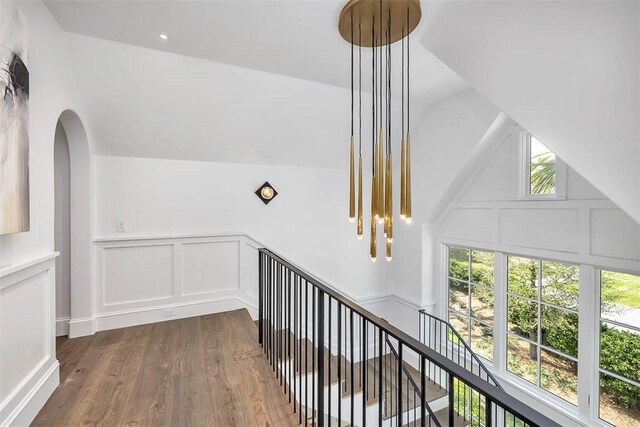 corridor with vaulted ceiling and hardwood / wood-style flooring