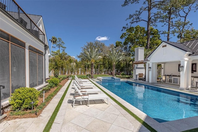 view of pool with area for grilling and a patio area