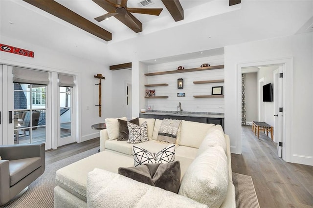 living room featuring beam ceiling, ceiling fan, light hardwood / wood-style flooring, and sink