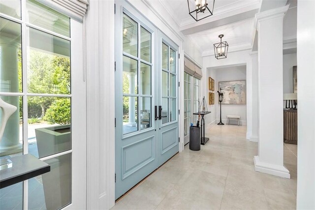 doorway to outside with crown molding and a chandelier