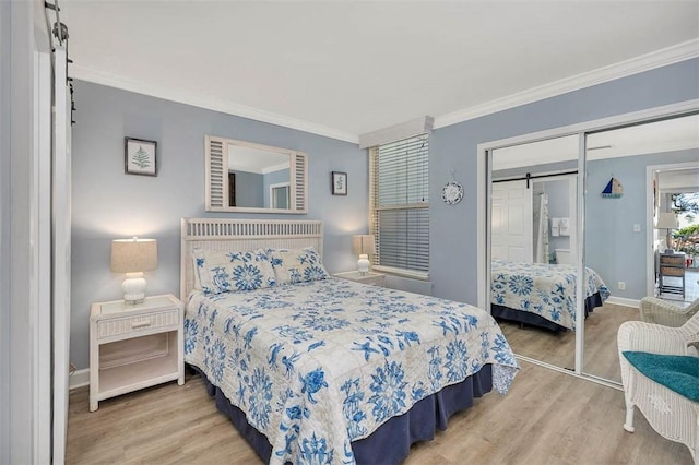 1175 N Beachview Dr Unit 279, Jekyll Island, GA 31527 - bedroom with wood finished floors, crown molding, a closet, baseboards, and a barn door