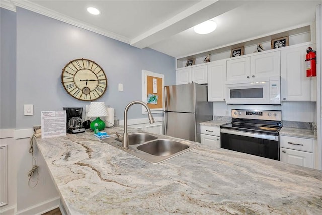 1175 N Beachview Dr Unit 279, Jekyll Island, GA 31527 - kitchen featuring stainless steel appliances, a sink, white cabinetry, ornamental molding, and light stone counters