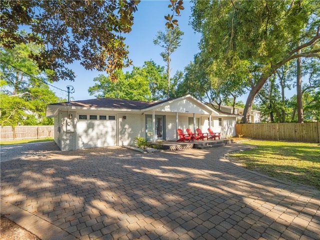 900 Mallory St, Saint Simons Island, GA 31522 - view of front facade featuring a garage, driveway, and brick siding