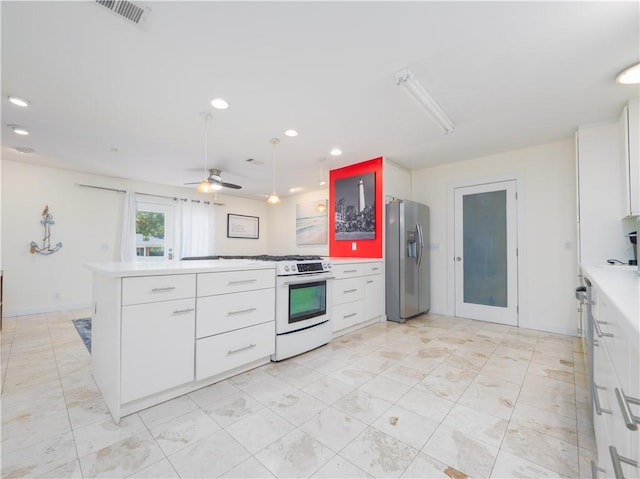 900 Mallory St, Saint Simons Island, GA 31522 - kitchen featuring stainless steel fridge with ice dispenser, range with gas stovetop, white cabinetry, light countertops, and a peninsula