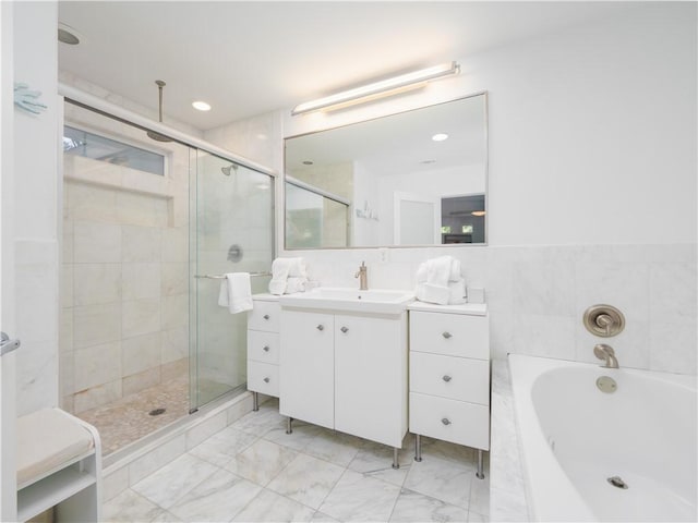 900 Mallory St, Saint Simons Island, GA 31522 - full bathroom with a shower stall, vanity, a garden tub, marble look tiles, and tile walls